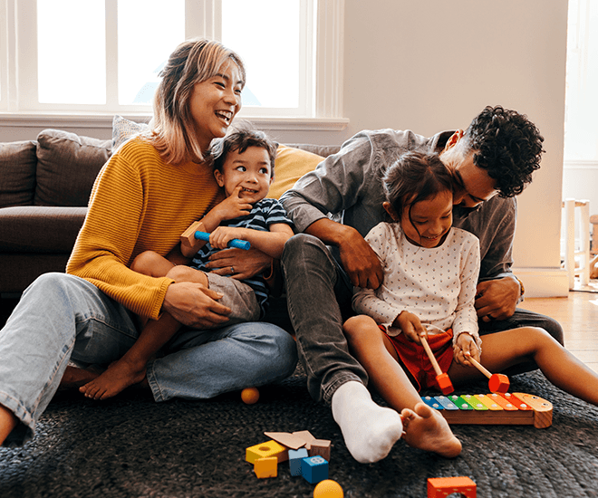 Happy family playing with kids in the living room of their home.