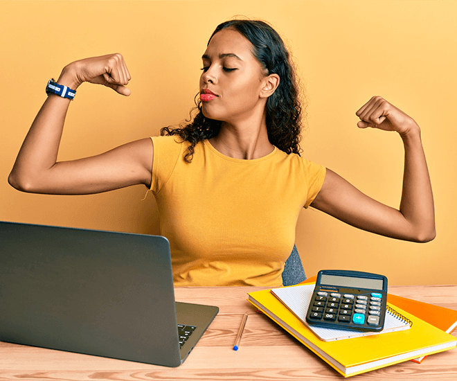 Woman showing off her arm muscles next to her laptop and calculator.