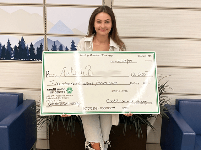 Autumn B. 2022 C·U·D Scholarship Winner holding giant check