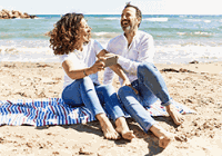 Middle-aged couple laughing on a beach