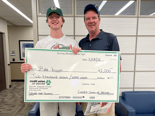 Blake K. 2022 C·U·D Scholarship Winner holding giant check