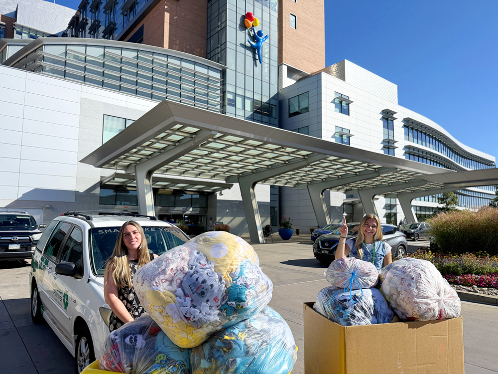 CUD employees posing with blanket sin front of Children's Hospital