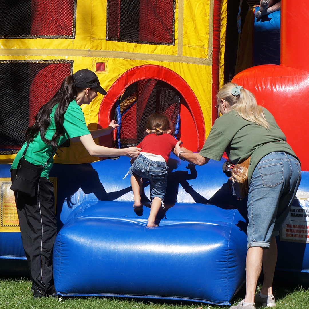 Kid being helped into the bounce castle