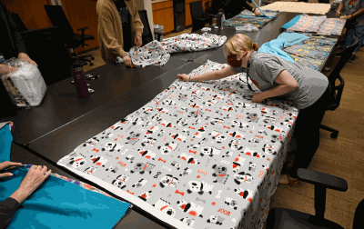 Volunteers working on no sew blanket