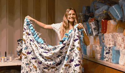Volunteer holding up completed no sew blanket