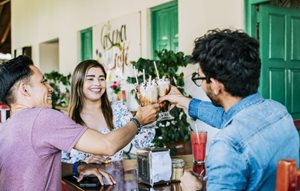 Happy friends enjoying milkshakes