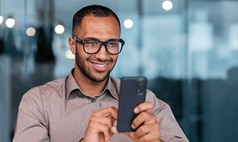 Man wearing glasses on his cell phone.