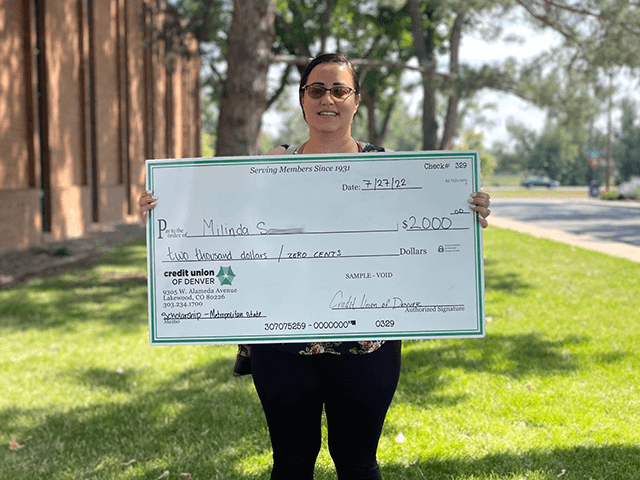 Milinda S. 2022 C·U·D Scholarship Winner holding giant check