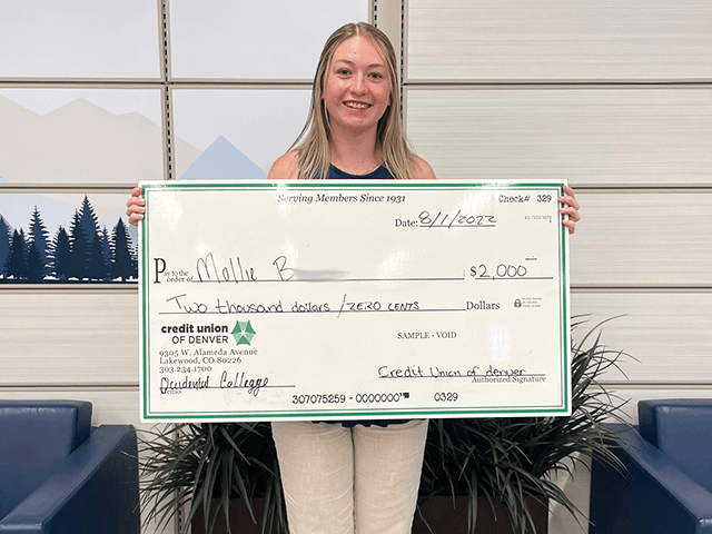 Mollie B. 2022 C·U·D Scholarship Winner holding giant check