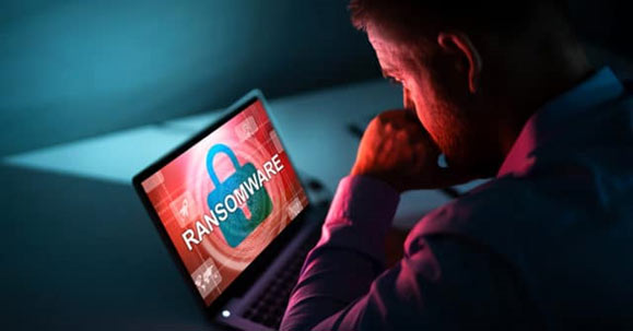 Man viewing ransomware warning on laptop