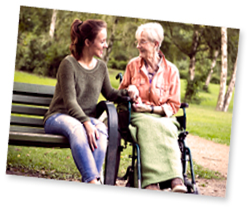 Woman on bench next to woman in a wheelchair