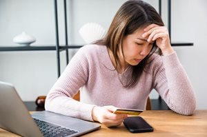 Stressed woman holding a credit card