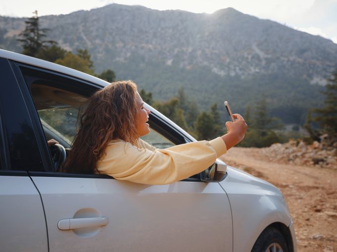 woman taking pictures out car window