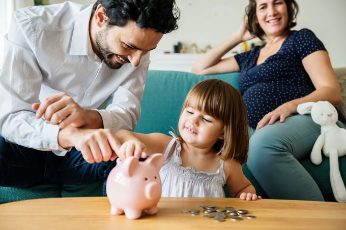 family saves money in a piggy bank