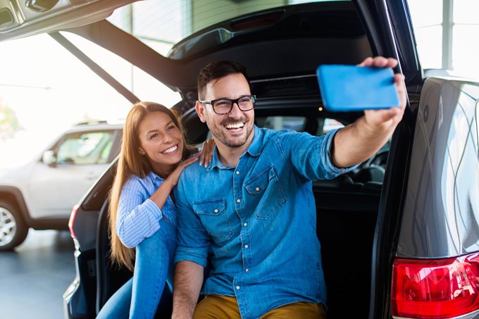 couple takes a selfie in their new car