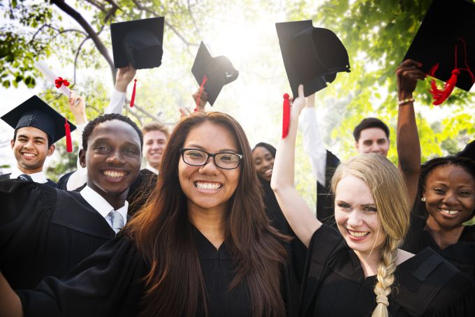 Students throw graduation caps in the air