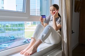 teen girl on phone holding credit card