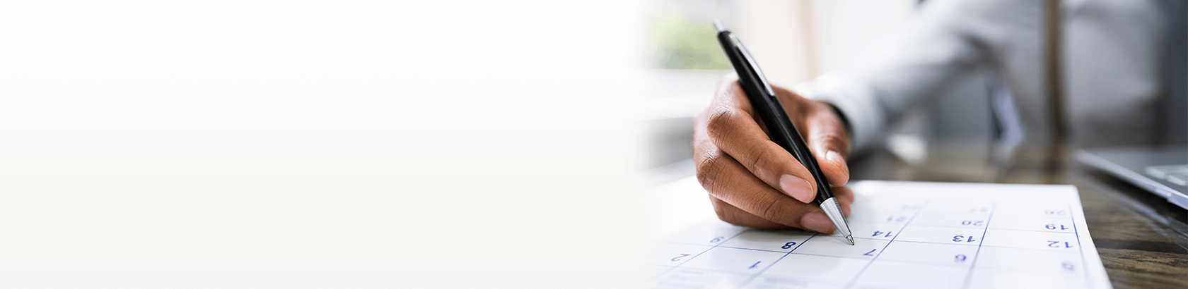 Man writing on his calendar with a pen on a specific date